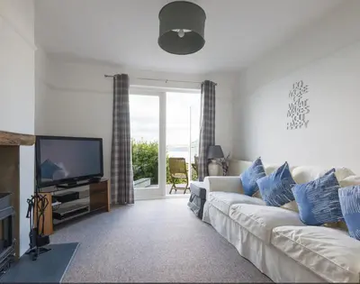 a living room with a white couch and a television at Signal Post in Port Isaac