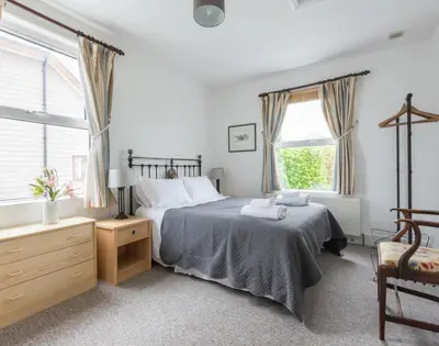 a bedroom with a bed and a large window at Signal Post in Port Isaac