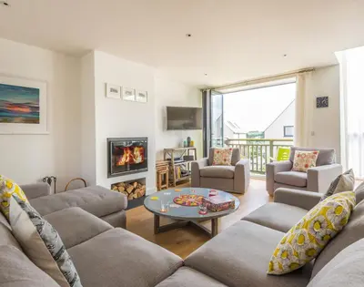 a living room with a couch and a fire place at Rainer Rocks in Polzeath