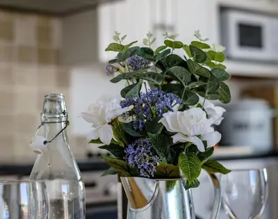 a vase with flowers in it on a table at The Folly in Port Isaac