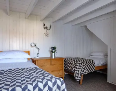 a bedroom with a bed and a dresser with a bed sidx sidx sidx sidx at The Folly in Port Isaac