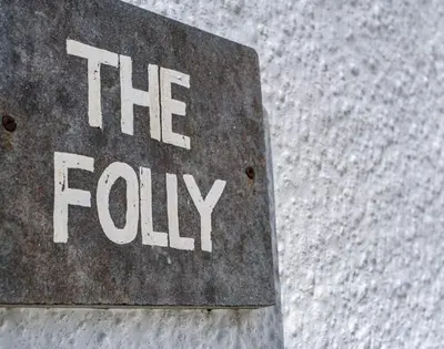 a sign that says the fyy on a stone wall at The Folly in Port Isaac