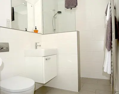 a white bathroom with a toilet and a sink at The Beach Hut in Polzeath