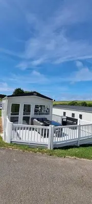 a white fence in front of a house at PV70 newquay bay resort in Porth