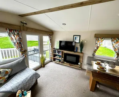 a living room with a couch and a tv at PV70 newquay bay resort in Porth