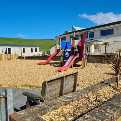 a park with a bench and a playground at PV70 newquay bay resort in Porth