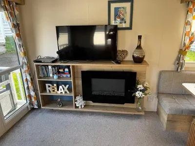 a living room with a flat screen tv on a entertainment center at PV70 newquay bay resort in Porth