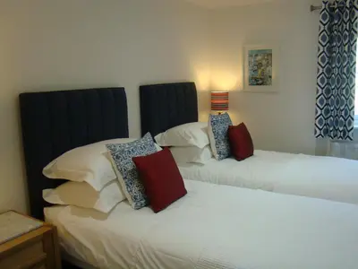 two beds sitting next to each other in a bedroom at Topsail - Falmouth in Falmouth