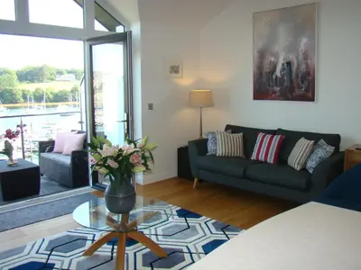 a living room with a couch and a table at Topsail - Falmouth in Falmouth