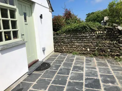 a door to a house with a stone driveway at Picture perfect cottage in rural Tintagel in Tintagel
