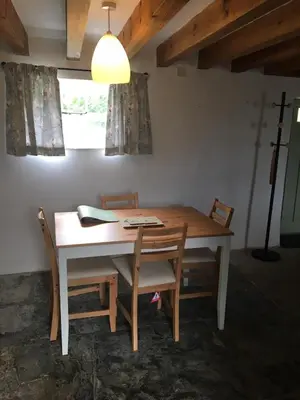 a dining room table with two chairs and a lamp at Picture perfect cottage in rural Tintagel in Tintagel
