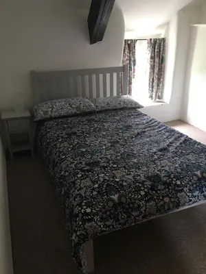 a bed in a bedroom with a blanket on it at Picture perfect cottage in rural Tintagel in Tintagel