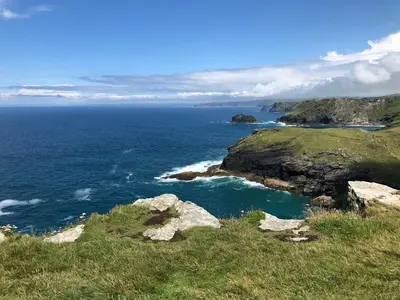 a view of the ocean from a hill with rocks at Picture perfect cottage in rural Tintagel in Tintagel