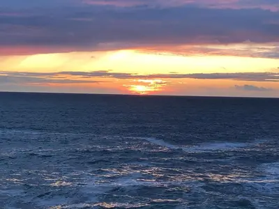 a sunset over the ocean with the sun setting at Picture perfect cottage in rural Tintagel in Tintagel