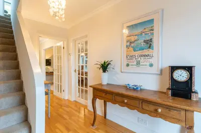 a room with a clock on a wooden table at Finest Retreats - Tideway in Saint Clement