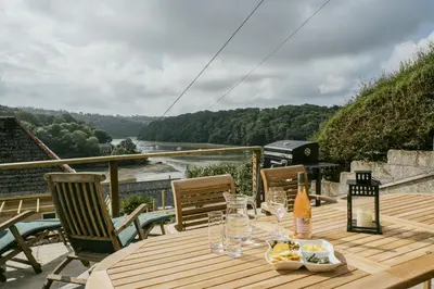 a wooden table with glasses and food on a deck at Finest Retreats - Tideway in Saint Clement