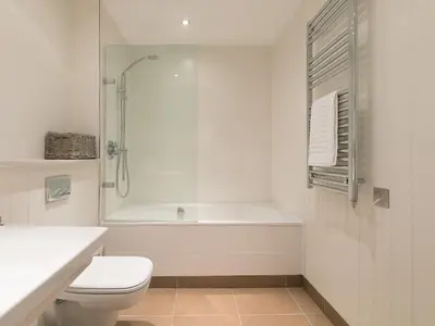 a white bathroom with a shower and a toilet at Crystal Bay in St Ives