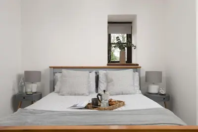a bedroom with a bed with a tray on it at The Old Hay Barn, Hot Tub, Pet Friendly in Ludgvan
