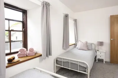 a bedroom with a bed and a window at The Old Hay Barn, Hot Tub, Pet Friendly in Ludgvan