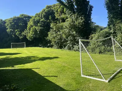 two soccer nets in a field with trees at The Old Hay Barn, Hot Tub, Pet Friendly in Ludgvan