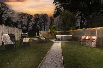 a backyard with a fire pit and a grill at The Old Hay Barn, Hot Tub, Pet Friendly in Ludgvan