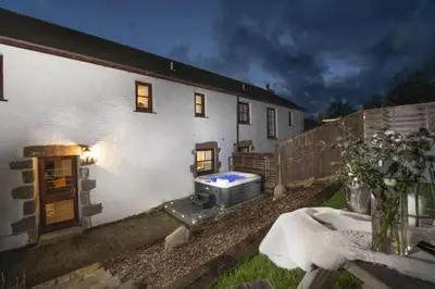 a white house with a heater in front of it at Aval Dor Barn, Hot Tub, Pet Friendly in Ludgvan