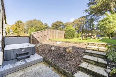 a backyard with a grill on a patio at Aval Dor Barn, Hot Tub, Pet Friendly in Ludgvan