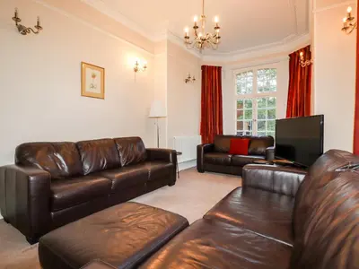 a living room with leather furniture and a tv at Lewarne in Boscastle