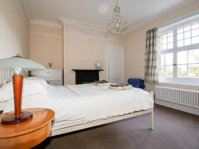 a bedroom with a large white bed with a table at Lewarne in Boscastle