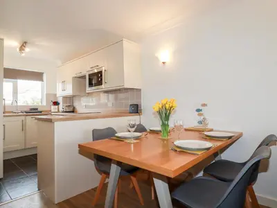 a kitchen and dining room with a wooden table and chairs at 7 Europa Court in Newquay