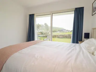 a bedroom with a large bed and a large window at 7 Europa Court in Newquay