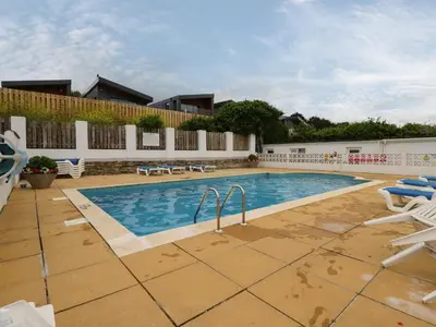 a large swimming pool with chairs at 7 Europa Court in Newquay