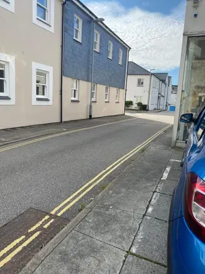 a street with houses and a blue car parked on the street at Apartment No 8 - Stay in style in the heart of the Cathedral City. in Truro