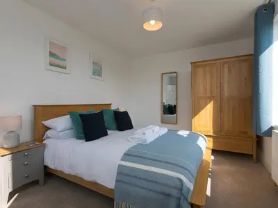 a bedroom with a bed with a blue and white blanket at Brynmaur in St Ives