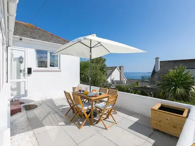 a table and chairs with an umbrella on a patio at Brynmaur in St Ives