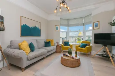 a living room with a couch and a tv at Summer Salt in St Ives