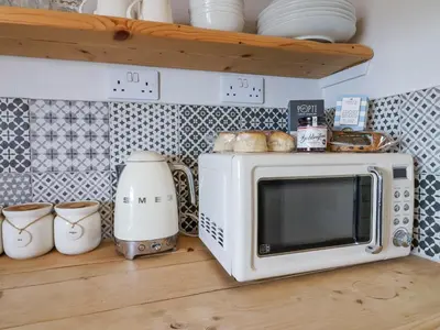 a microwave oven sitting on top of a kitchen counter at 2 Cliff Cottages in Truro