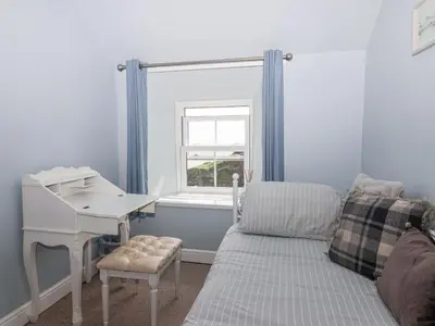 a room with a desk and a bed and a window at 2 Cliff Cottages in Truro