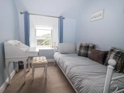a living room with a couch and a desk at 2 Cliff Cottages in Truro