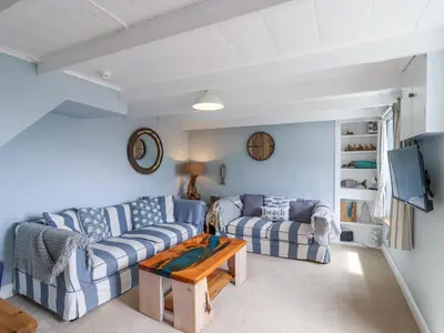 a living room with two couches and a table at 2 Cliff Cottages in Truro