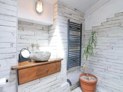 a bathroom with a sink and a potted plant at 2 Cliff Cottages in Truro