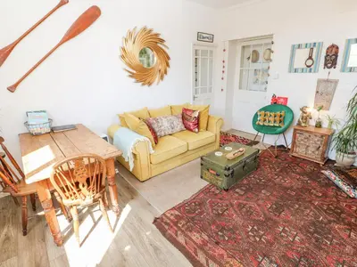 a living room with a yellow couch and a table at The Cottage in Penzance