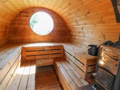 an empty wooden room with a window in a log cabin at The Cottage in Penzance