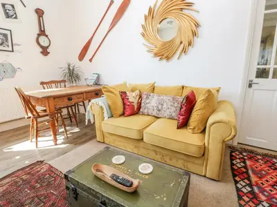 a living room with a couch and a table at The Cottage in Penzance