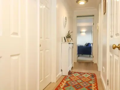a hallway with a door and a rug at The Wesley Apartment in Falmouth