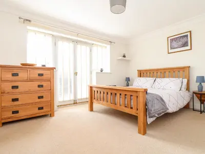 a bedroom with a wooden bed and a dresser at The Wesley Apartment in Falmouth