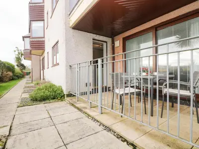 a balcony of a house with a table and chairs at The Wesley Apartment in Falmouth