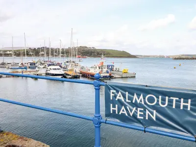 a marina with boats in the water and a sign at The Wesley Apartment in Falmouth