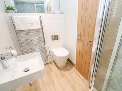 a bathroom with a toilet and a sink and a shower at Postcard Lodge in Fowey