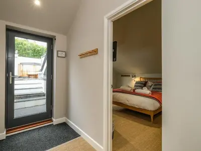 a bedroom with a bed and a sliding glass door at Postcard Lodge in Fowey
